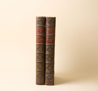deux vieux livres posés l'un sur l'autre sur une surface blanche