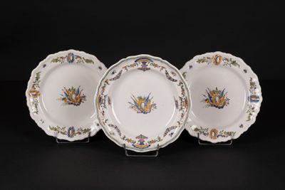 three plates with floral designs on them sitting on a black surface