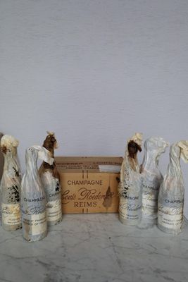 four bottles of champagne sitting on a table next to a box of wine
