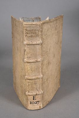 un vieux livre posé sur une table à côté d'un mur gris
