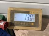 un compteur numérique posé sur une table à côté d'une paire de fils électriques