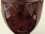 a brown glass vase with a silver base on a white background