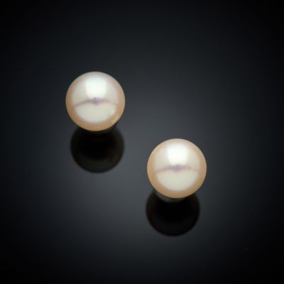 une paire de perles blanches sur un fond noir