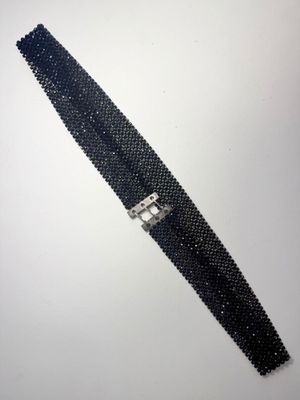 un gros plan sur une ceinture en perles noires avec une boucle argentée