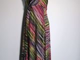 a woman ' s dress on a mannequin stand against a wall
