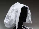 un gros plan sur une tête de mannequin recouverte d'un tissu blanc