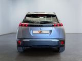 the rear end of a silver car parked in a white room