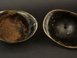 pair of antique brass bowls on a black background