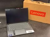 lenovo laptop with box and charger on table next to it