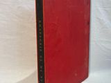 a red book sitting on top of a white cloth covered table