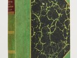 un livre vert et noir posé sur une table blanche