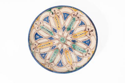 une assiette bleue et jaune posée sur un fond blanc
