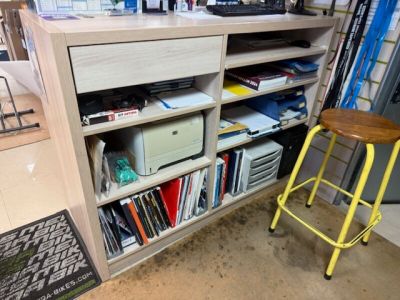a yellow stool sitting in front of a bookshelf filled with books