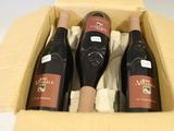 trois bouteilles de vin dans un carton sur une table
