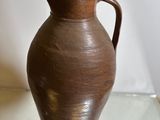a brown vase that is sitting on a glass table