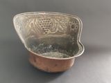 a small metal bowl with a handle on a table