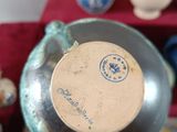 a close up of a vase on a table with other vases in the background