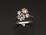 une image d'une bague en diamant sur une surface noire