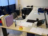 un bureau encombré de papiers, dans une pièce