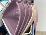 a pile of different colored plastic dishes and pans on a table