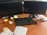 a desk with two computer monitors and a keyboard on it