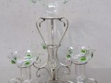 un bougeoir en verre surmonté de quatre verres