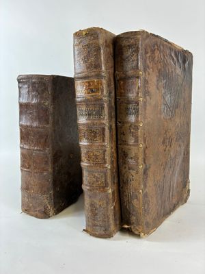 two old books sitting next to each other on a white surface