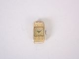 une petite montre-bracelet en or posée sur une surface blanche
