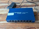 une photo d'un routeur Netgear bleu posé sur une table en bois