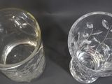 two glass vases sitting next to each other on a table