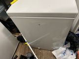 a white refrigerator sitting in the corner of a room