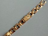 a close up of a gold bracelet on a gray surface