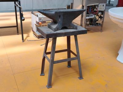 une vieille enclume posée sur un tabouret dans une pièce