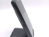 a black cell phone sitting on top of a stand