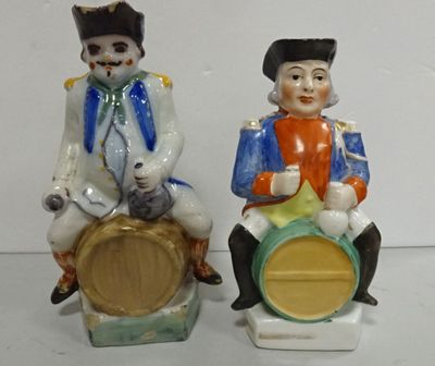 deux figurines représentant un homme et une femme assis sur un tonneau