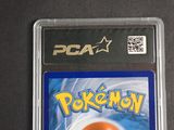 the pokemon card is in a plastic holder on a table