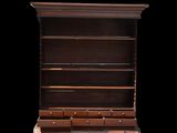 an old wooden bookcase with drawers and a clock on top of it