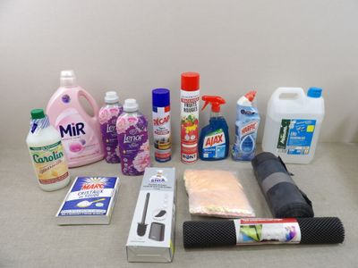 various cleaning products on a counter top next to a roll of toilet paper