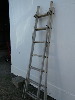 a ladder leaning against a white wall next to a building