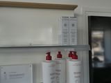 three bottles of lotion sitting on a shelf in a bathroom