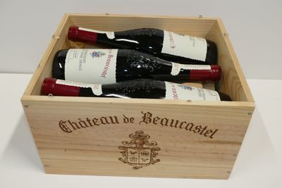 three bottles of wine in a wooden box on a table
