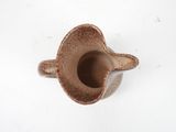 a small brown vase on a white surface