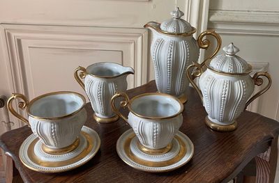five cups and saucers on a table with gold trimming