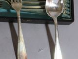 a lot of silver spoons and forks sitting on a table