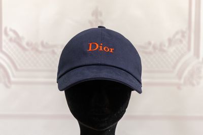 blue baseball cap with orange dior embroidered on the front