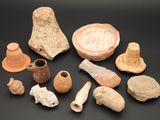 Plusieurs pièces de poterie sont exposées sur un fond noir