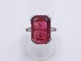 a close up of a ring with a red stone in it
