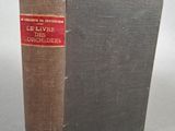 un vieux livre posé sur une table à côté d'un mur blanc