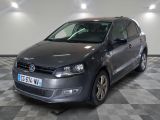 La Volkswagen Polo est garée dans une grande pièce au sol carrelé d'un motif à damier.