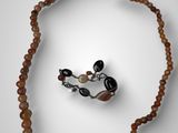 une image représentant un collier avec des perles et une bague sur un fond blanc